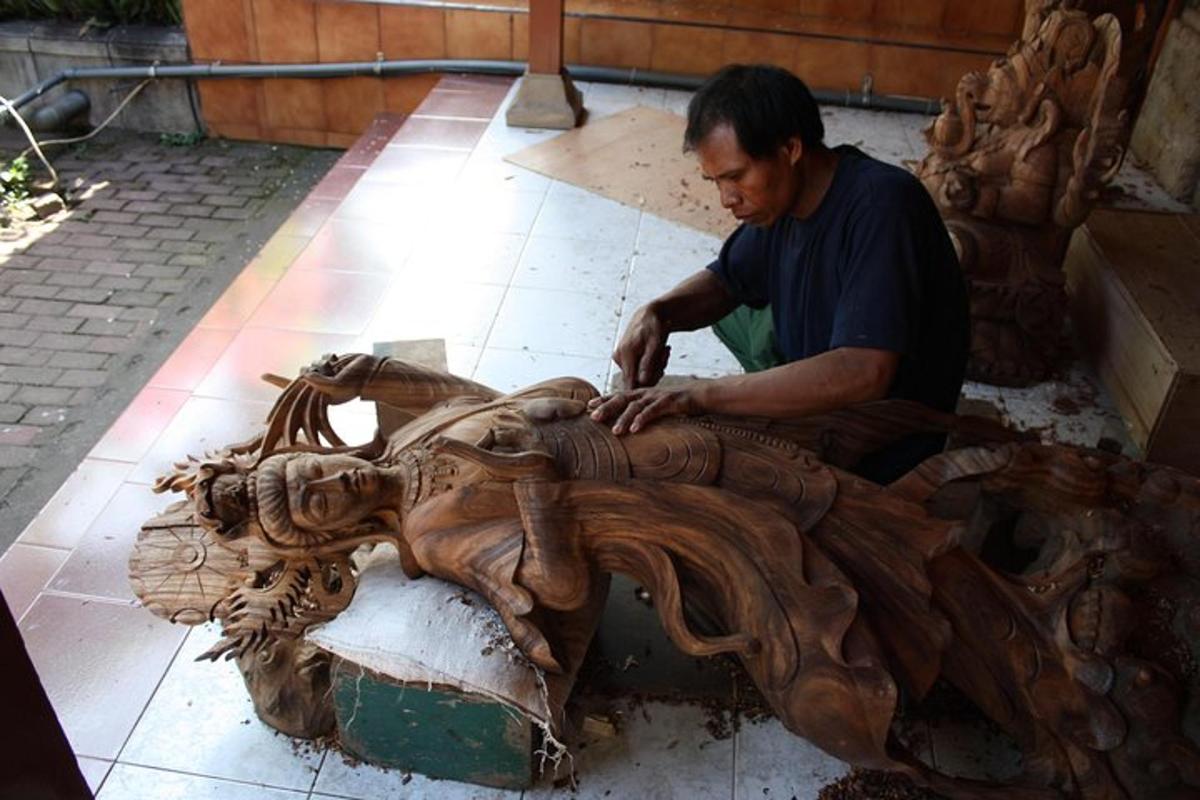 un bărbat care lucrează la o sculptură din lemn a unui animal