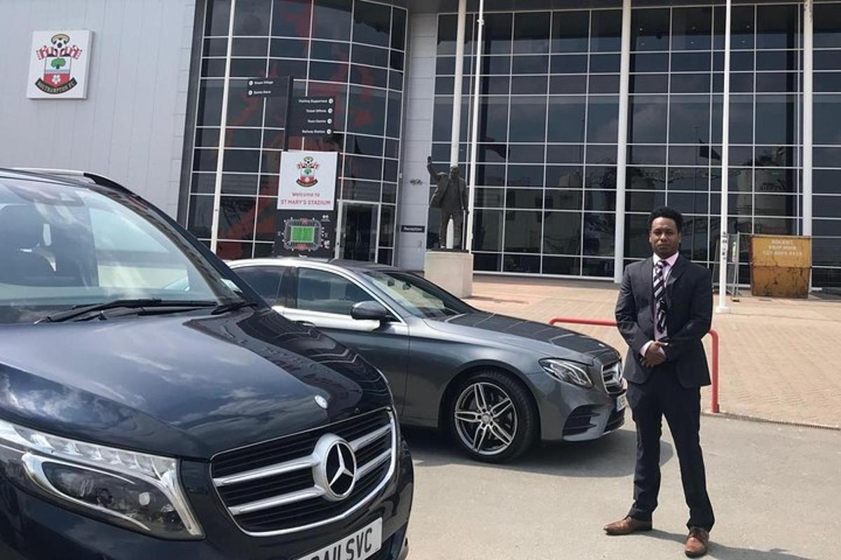 a man in a suit standing next to a car