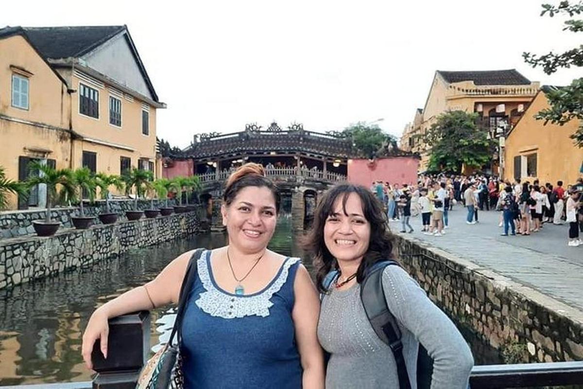 twee vrouwen staan naast een rivier in een stad