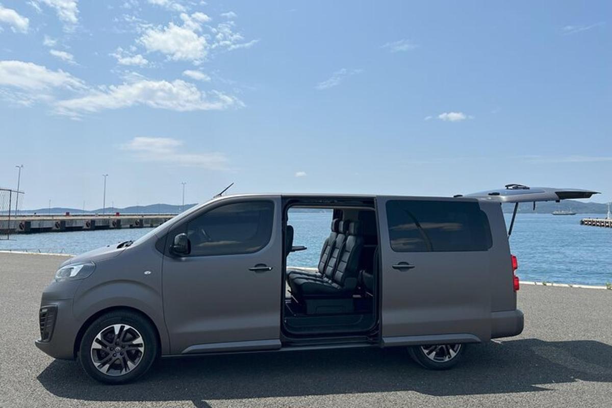uma van cinza com uma prancha de surfe na traseira