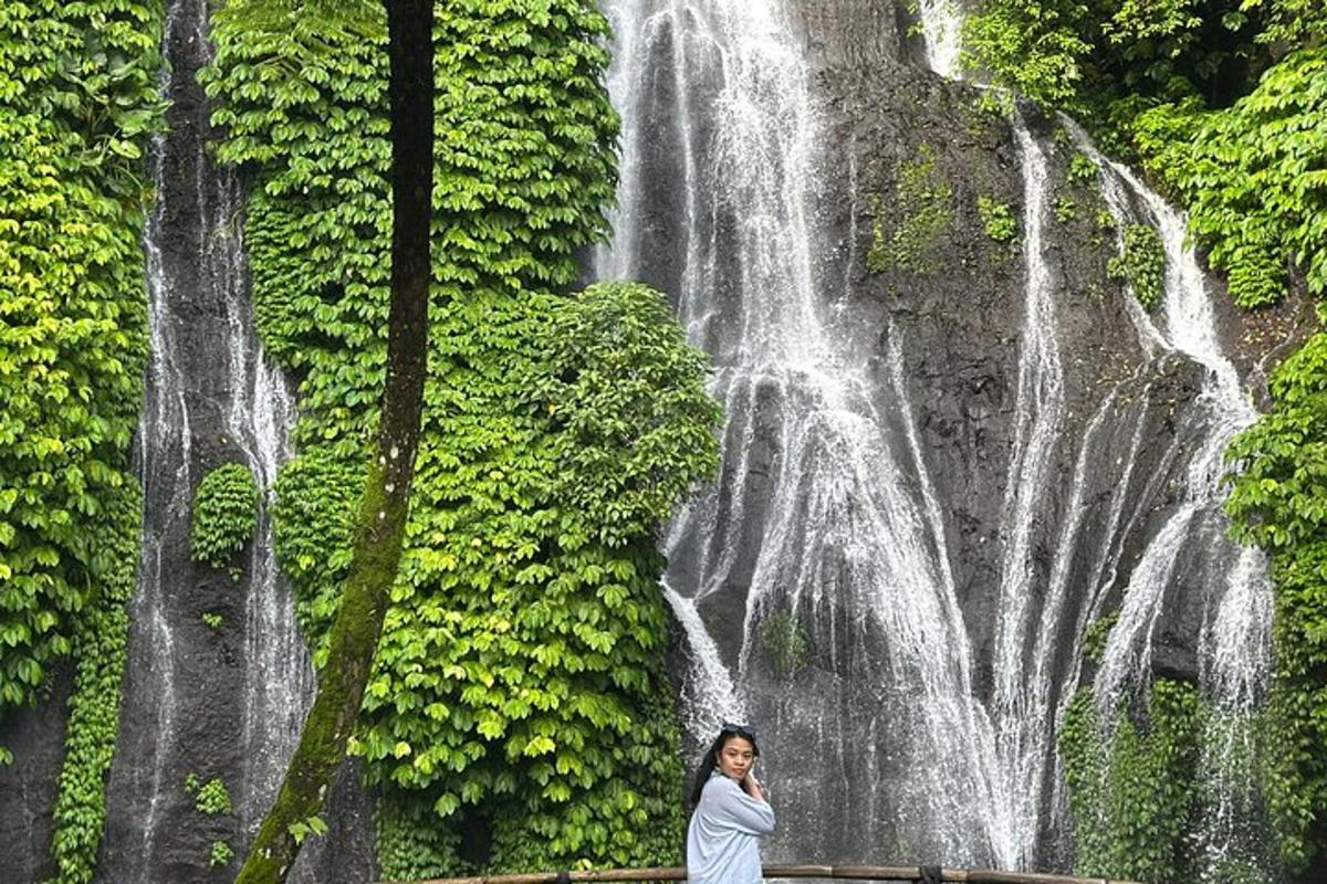 a woman standing in front of a waterfall