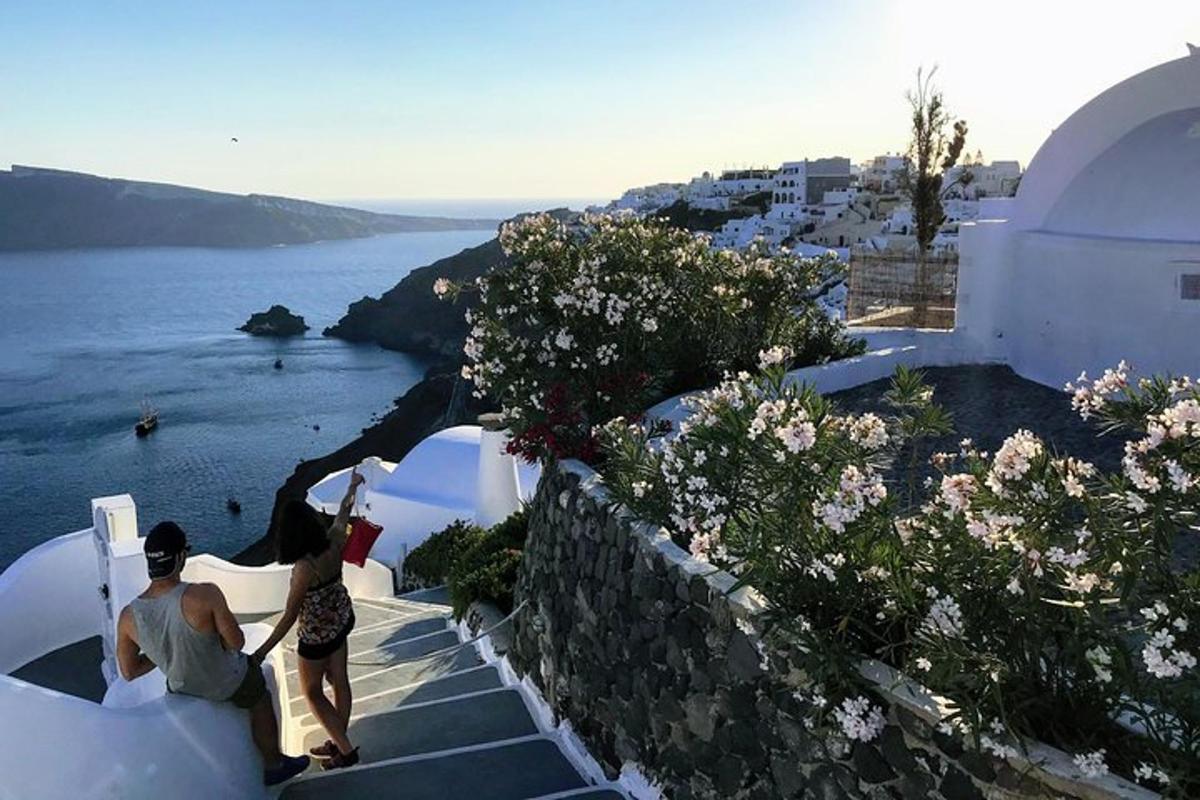 muž a žena stojící na schodech a dívající se na oceán