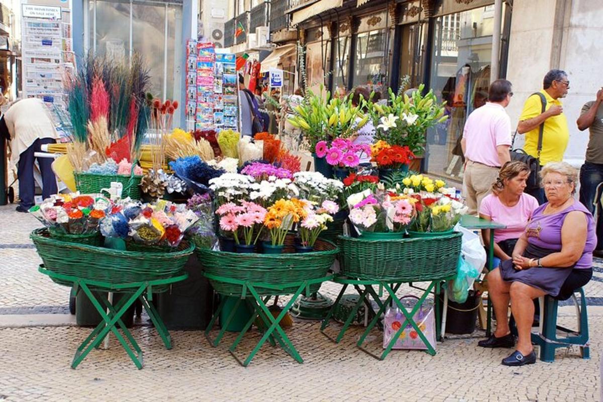 Un grupo de flores en cestas en un mercado.