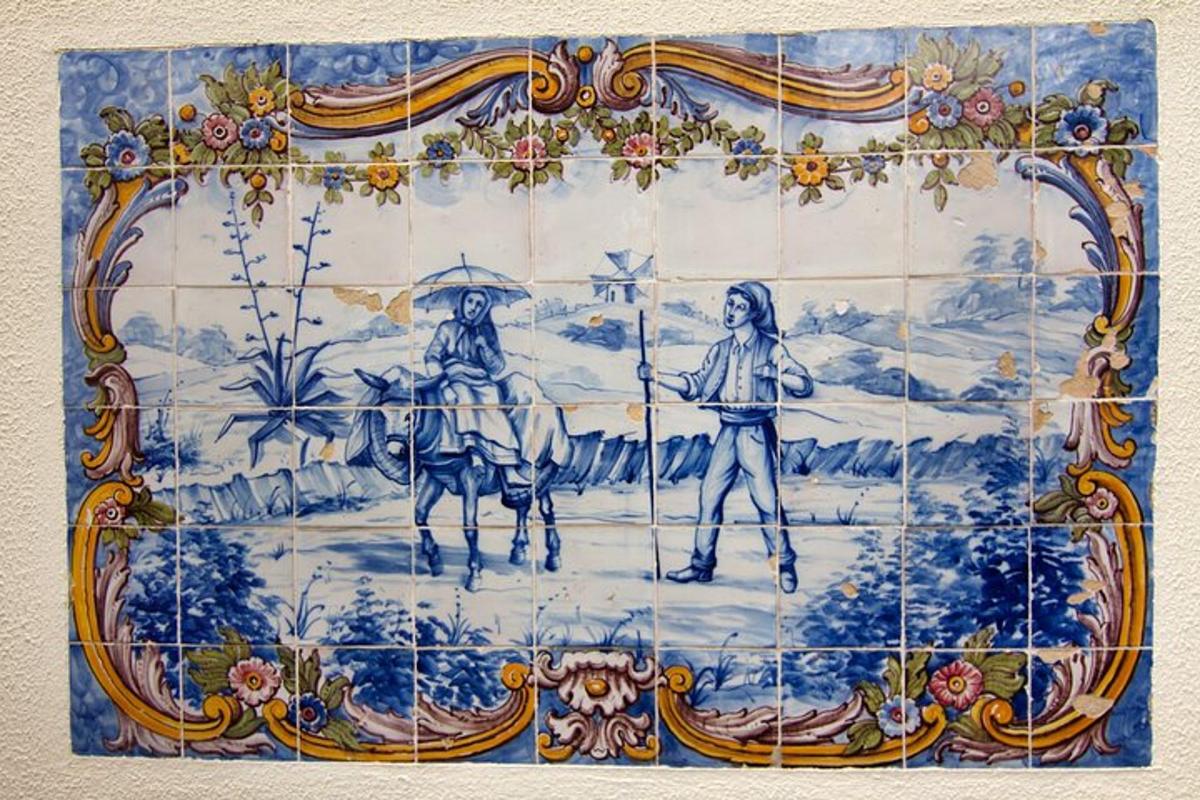 Una pared de azulejos con un hombre a caballo con un paraguas.