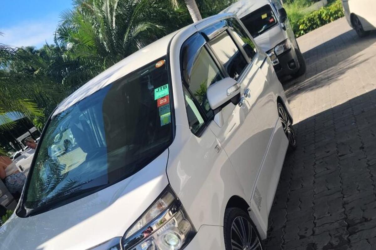 sebuah mobil van putih diparkir di pinggir jalan