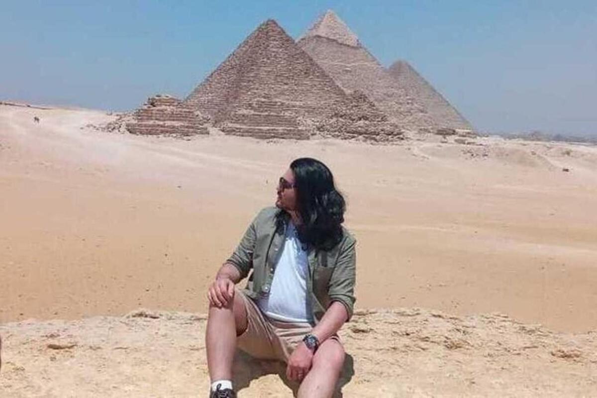 um homem sentado em frente às pirâmides