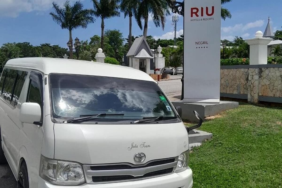 uma van branca estacionada em frente a uma placa