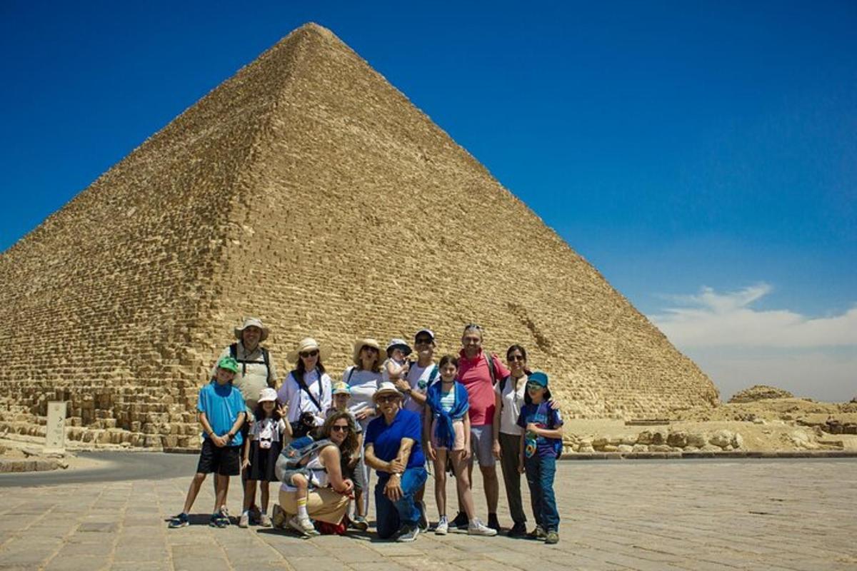 um grupo de pessoas em pé em frente a uma pirâmide