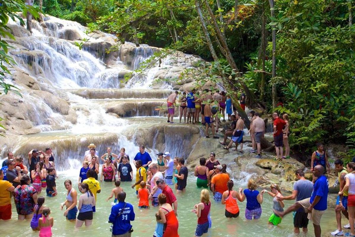 un gruppo di persone in piedi nell'acqua vicino a una cascata