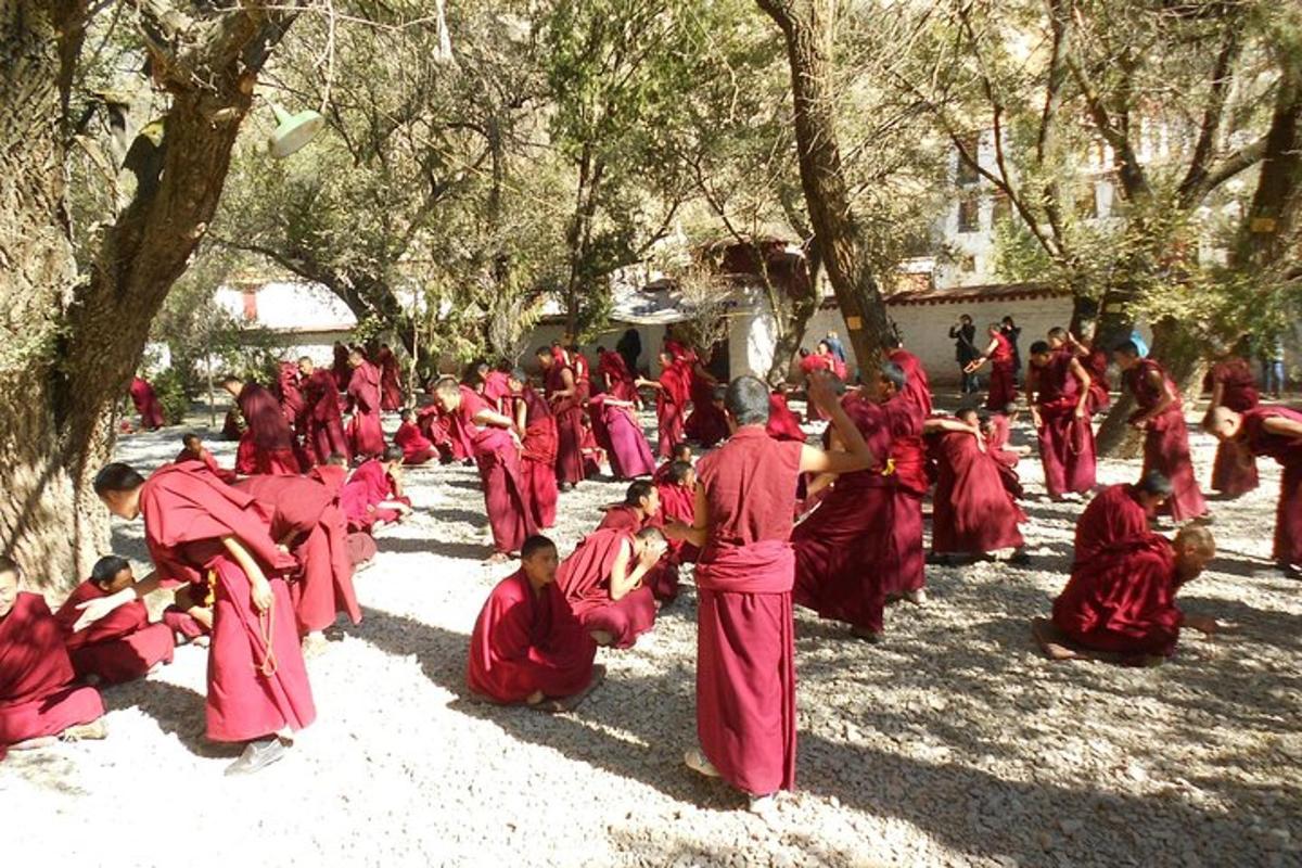a group of people in red robes sitting on the ground
