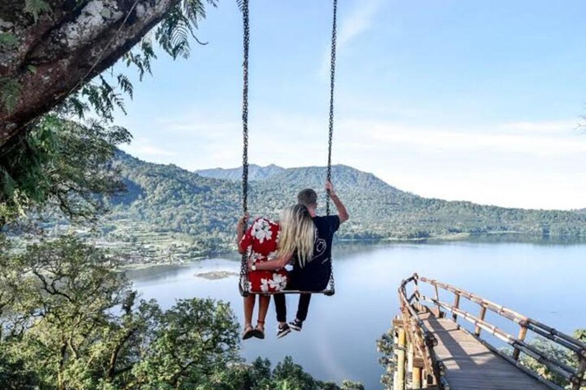 Pár sedící na houpačce s výhledem na jezero