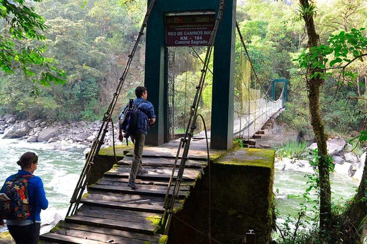 un uomo che cammina su un ponte sospeso sopra un fiume
