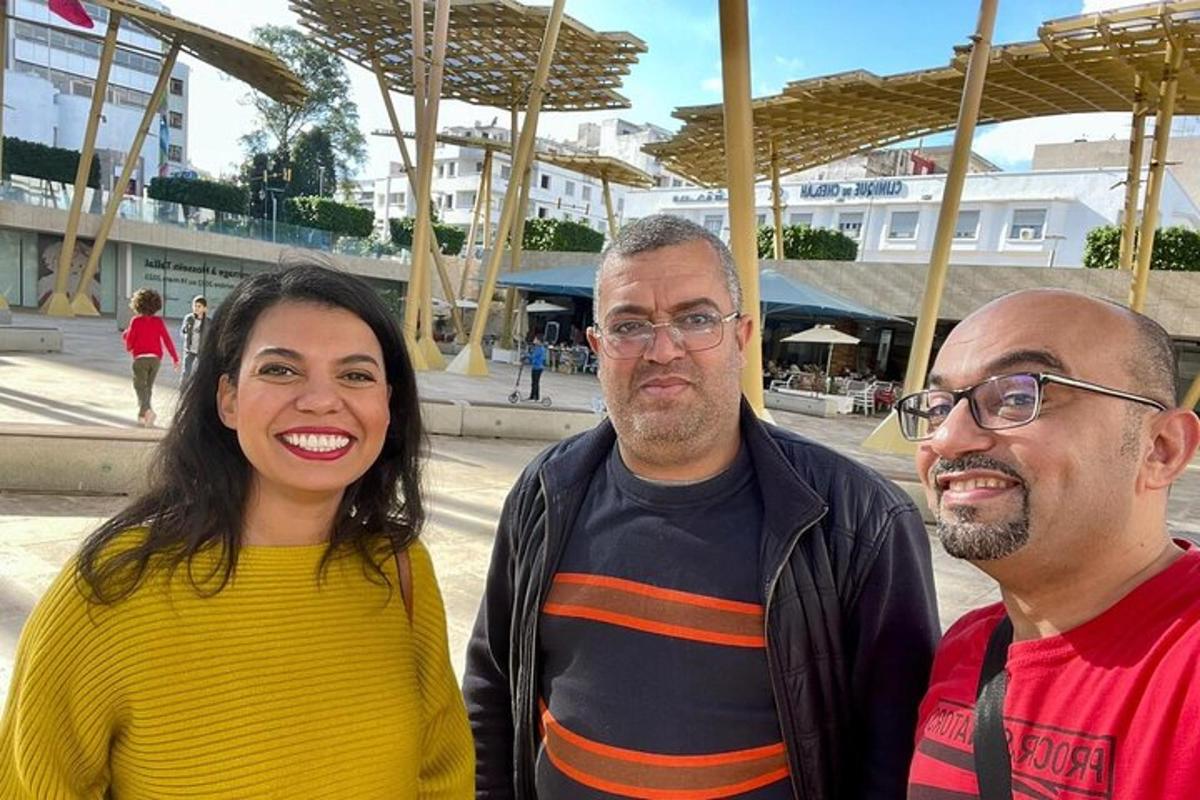 two men and a woman posing for a picture