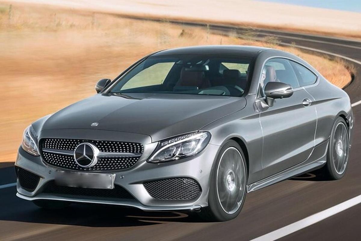 una Mercedes Benz argentata che percorre una strada