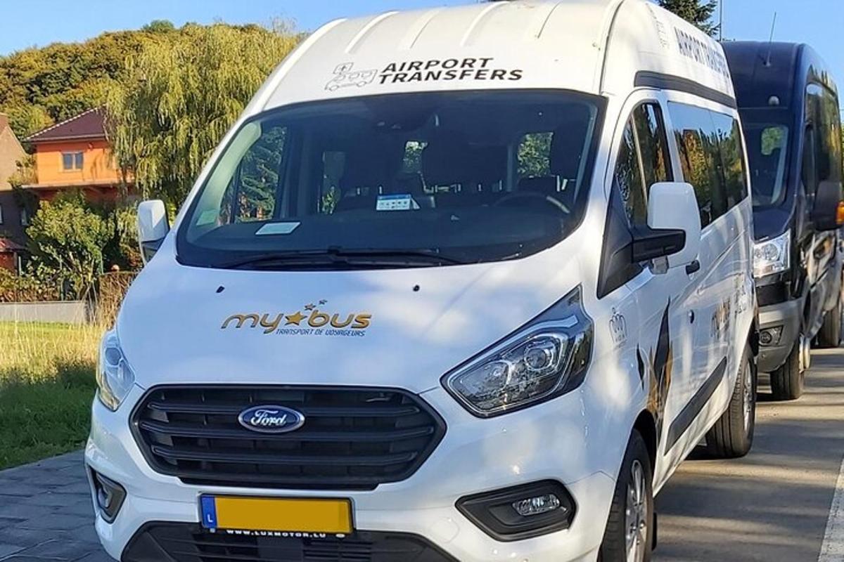 ένα άσπρο βαν παρκαρισμένο δίπλα σε ένα λεωφορείο