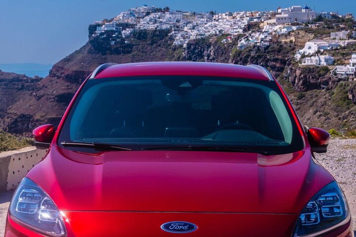 un'auto rossa parcheggiata sul fianco di una montagna