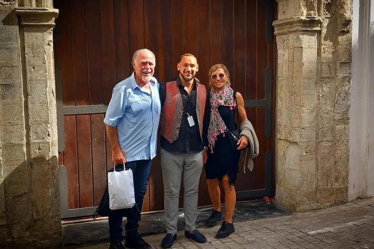 um grupo de três pessoas em pé em frente a uma porta