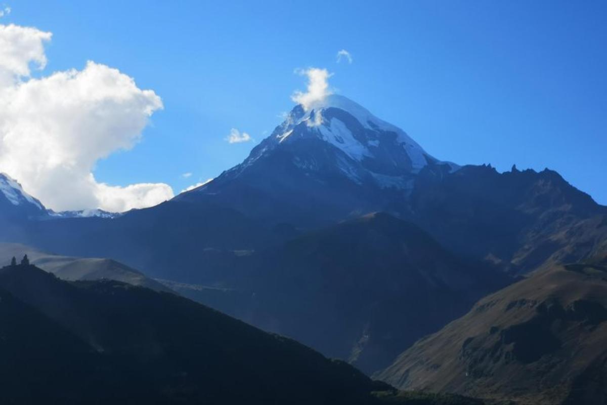 Una vista de una montaña con un cielo azul y nubes.