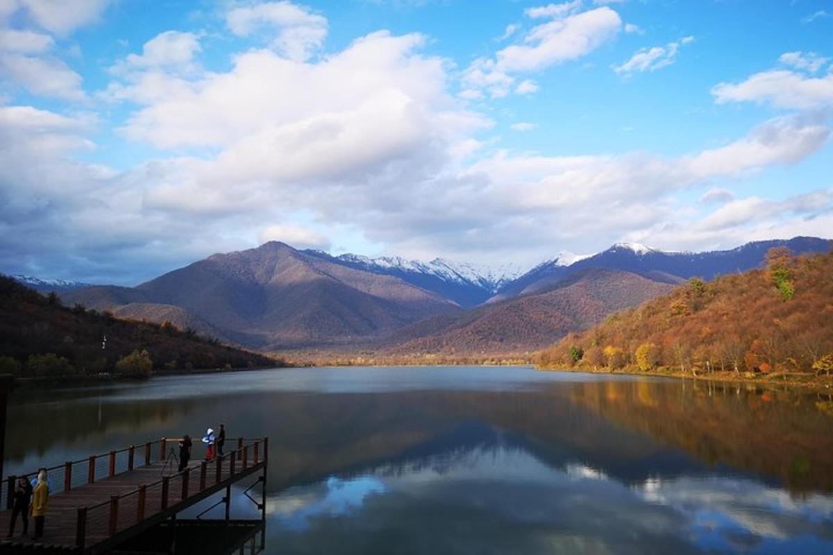 un ponte sopra un lago con le montagne sullo sfondo