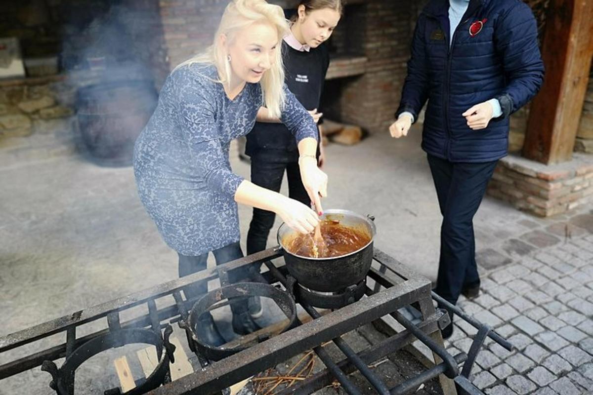 en kvinne som lager mat i en gryte på en grill