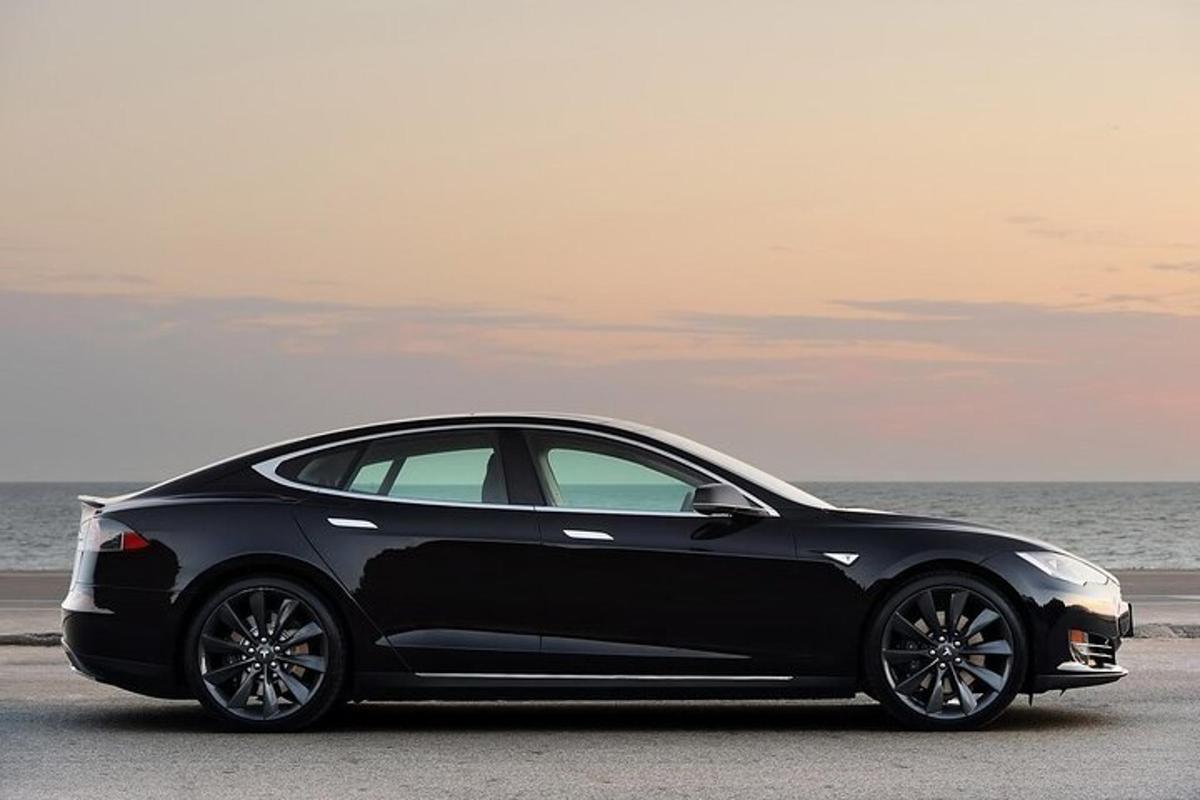 a black car parked next to the ocean