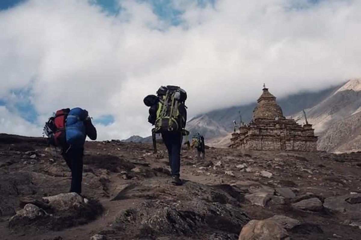 two people with backpacks on top of a mountain