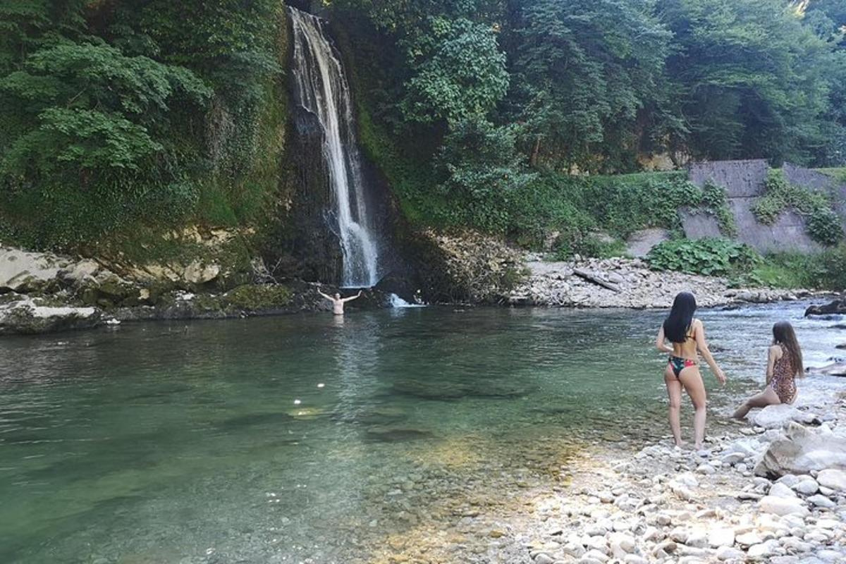 dues dones dempeus a l'aigua prop d'una cascada