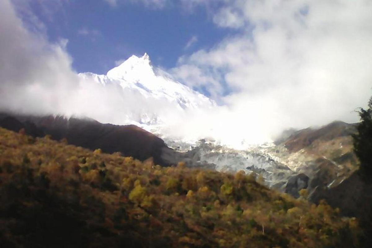 a snow covered mountain in the middle of a valley