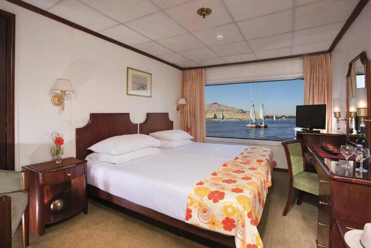 ein Schlafzimmer mit Bett und Blick aufs Wasser