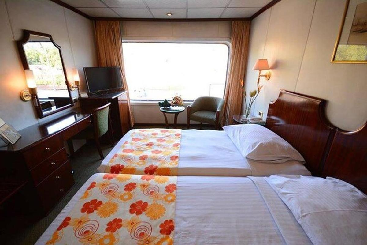 ein Schlafzimmer mit einem Bett, einem Schreibtisch und einem Fenster