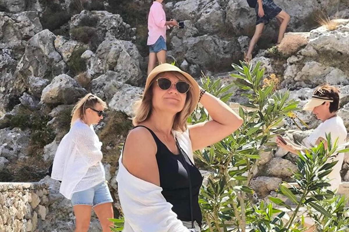 žena ve slunečních brýlích a klobouku a lidé na skalách