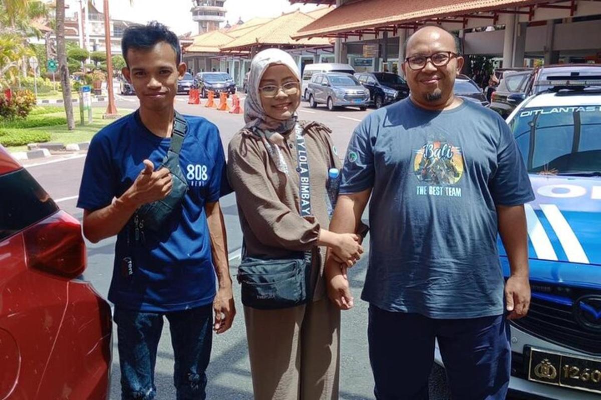 sekumpulan tiga orang berdiri di sebelah kereta