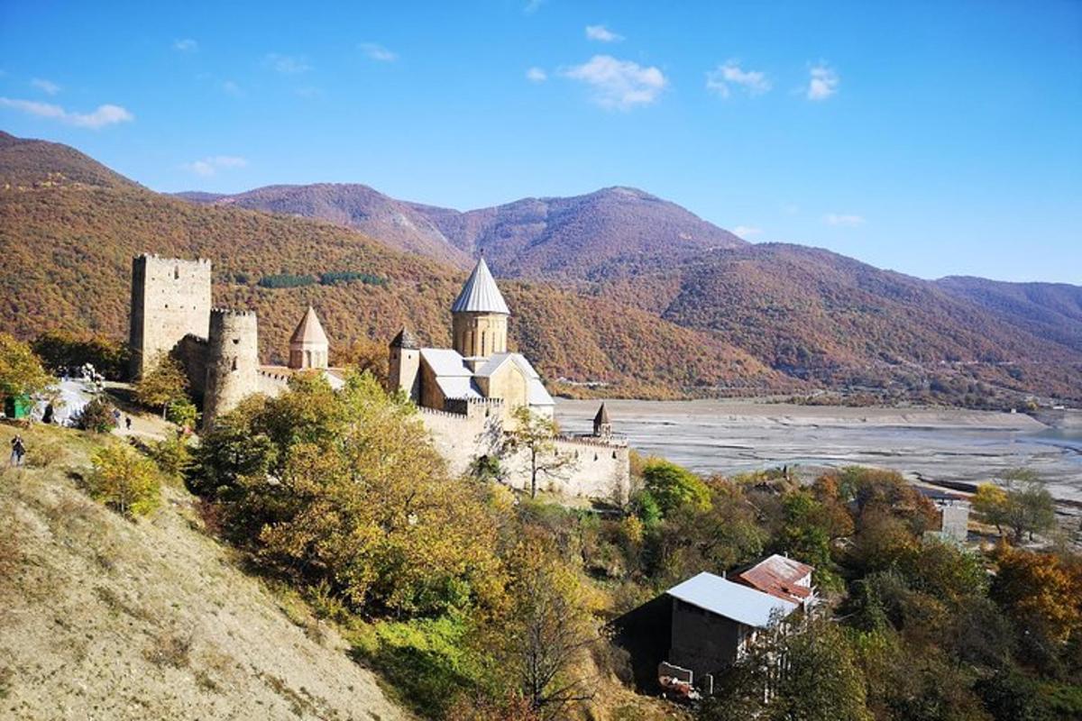 un castello in cima a una collina vicino a un fiume