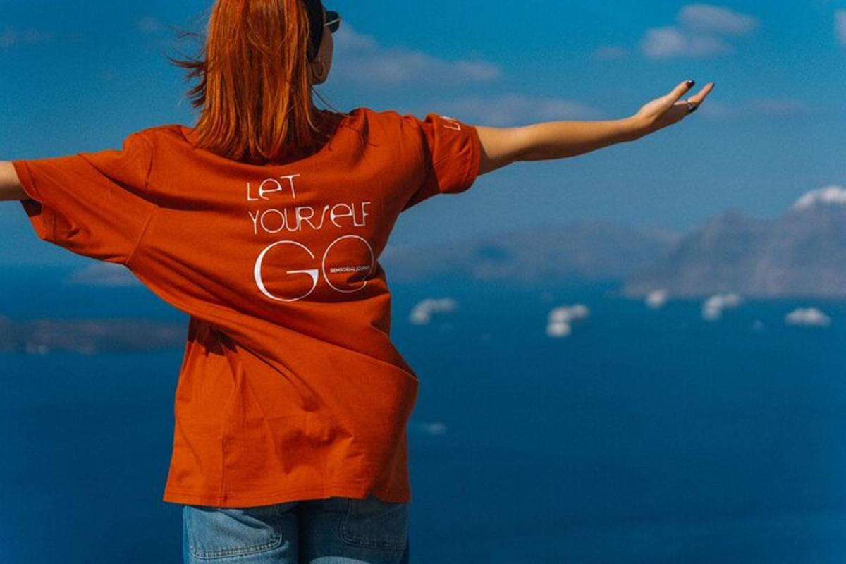une femme debout au sommet d'une montagne, les bras tendus