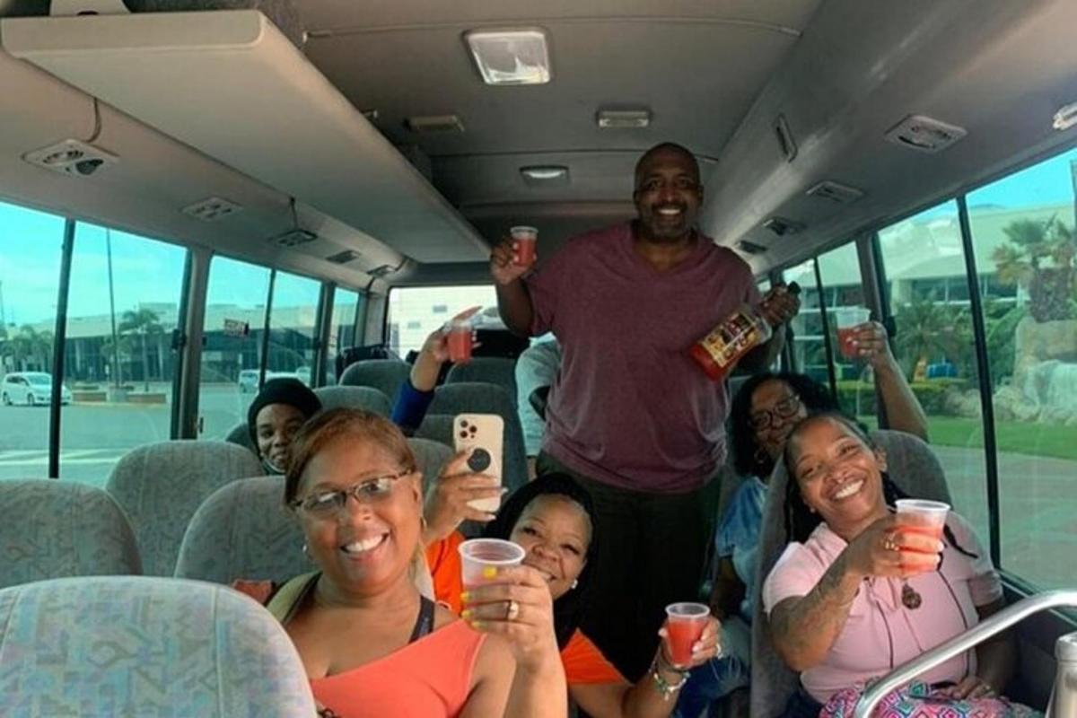 Un grupo de personas sentadas en un autobús sosteniendo bebidas.