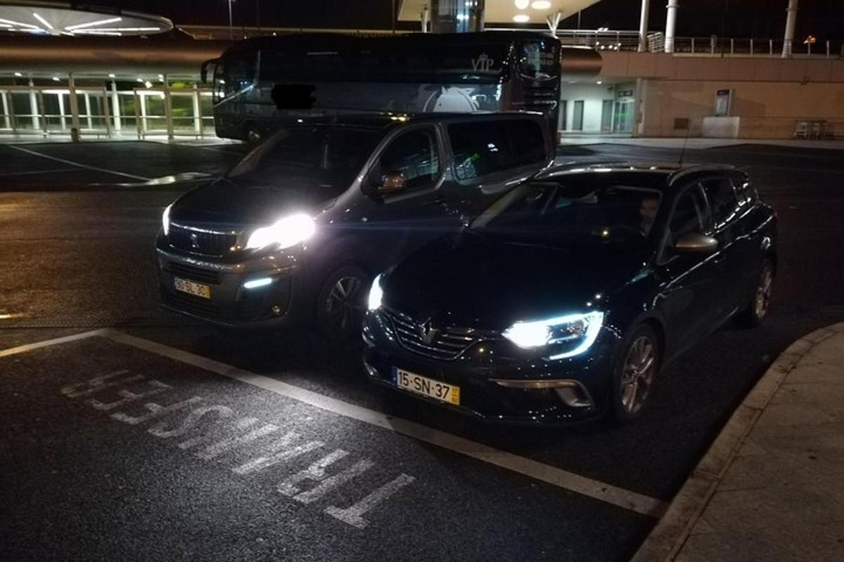 ein schwarzes Auto, das nachts auf einem Parkplatz geparkt ist