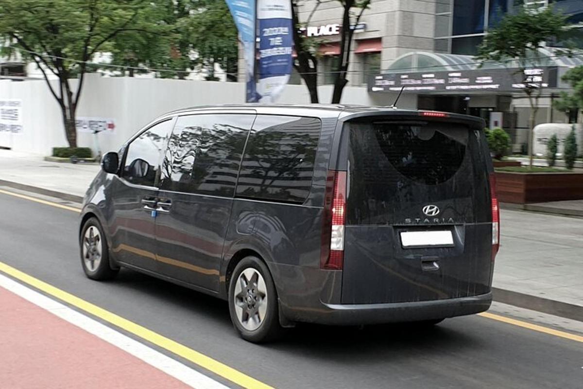 sebuah mobil van hitam melaju di jalan kota