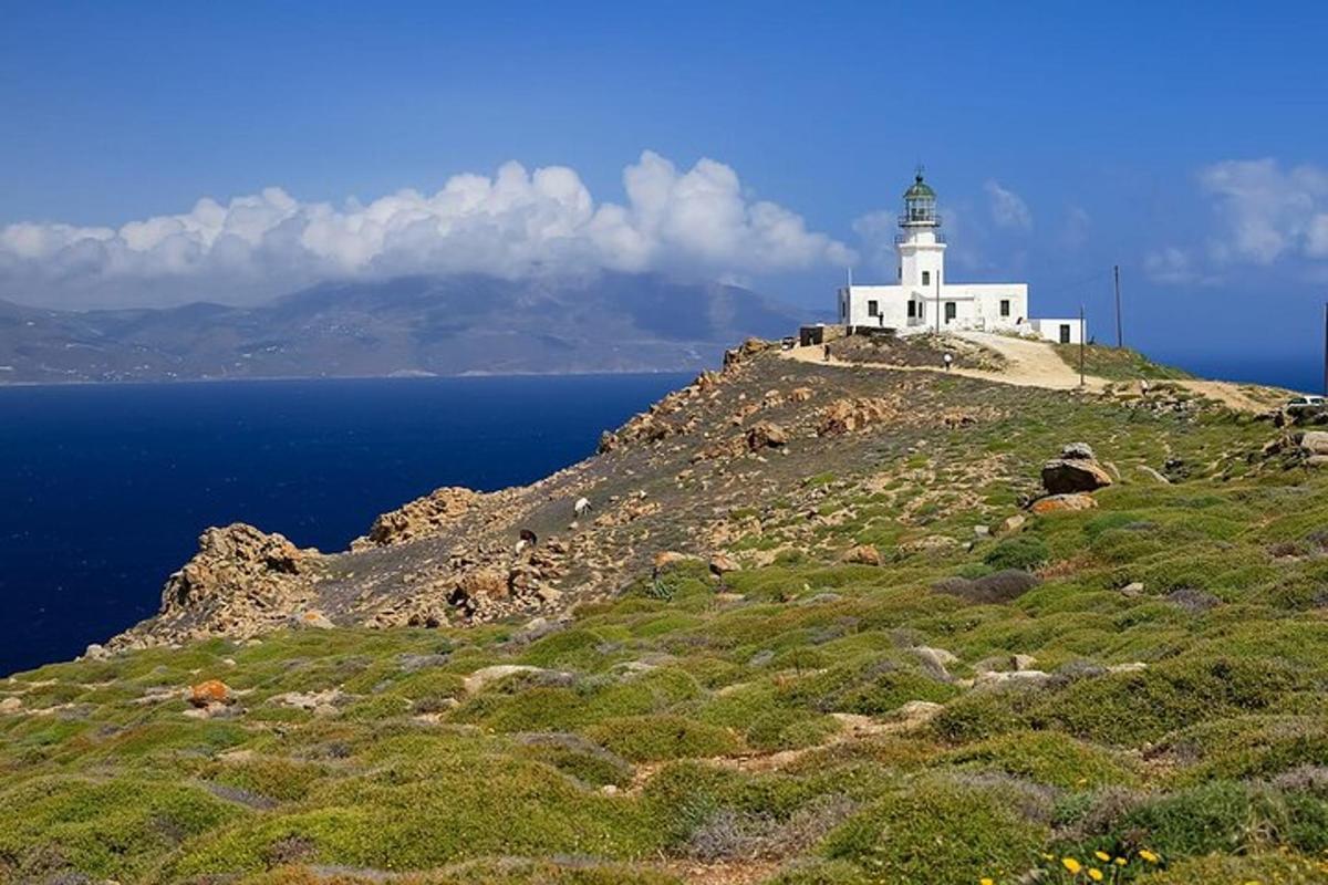 um farol no topo de uma colina com o oceano