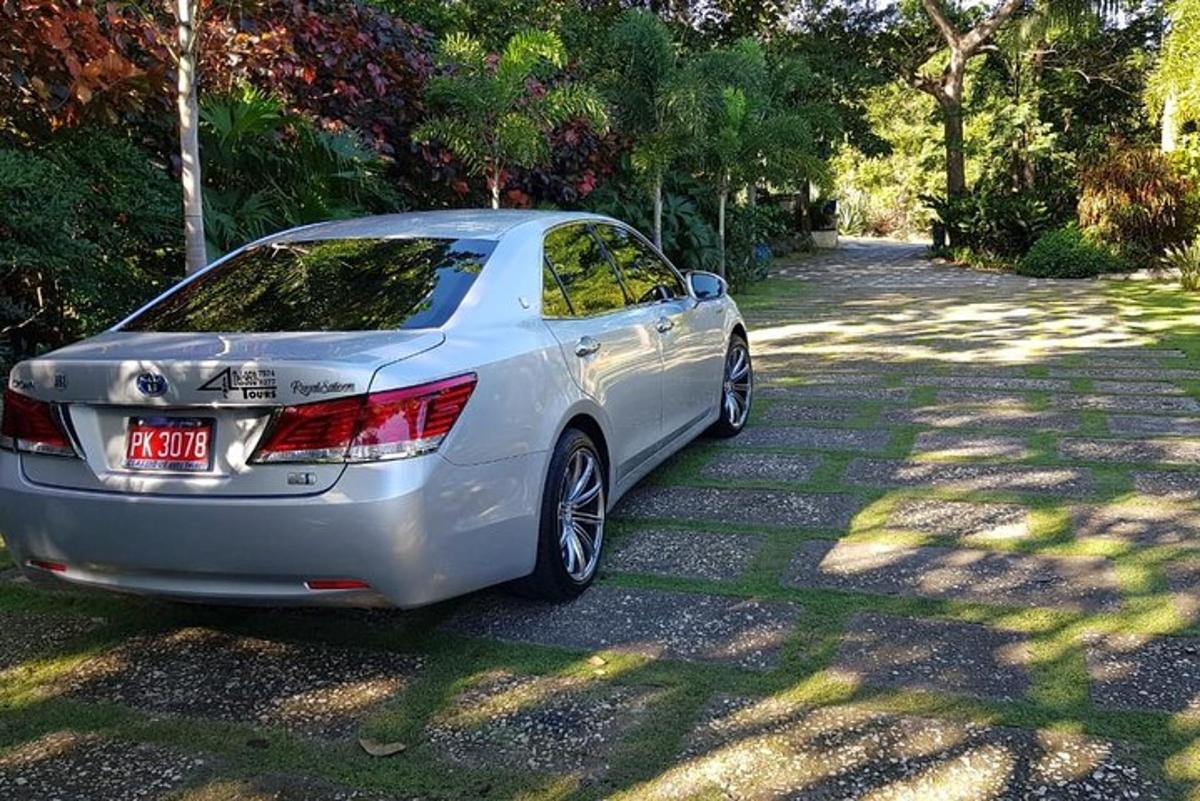 Un coche plateado aparcado en un camino de grava