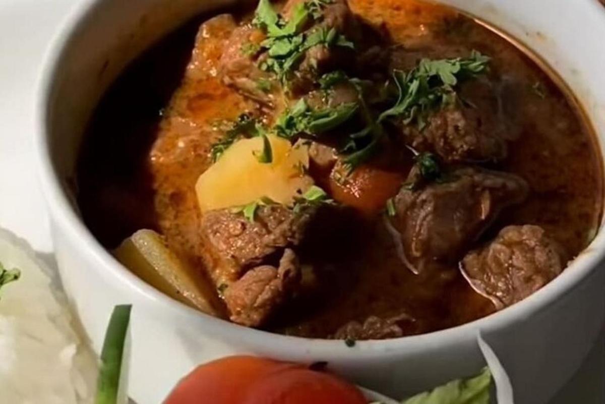 a bowl of soup with meat and vegetables in it