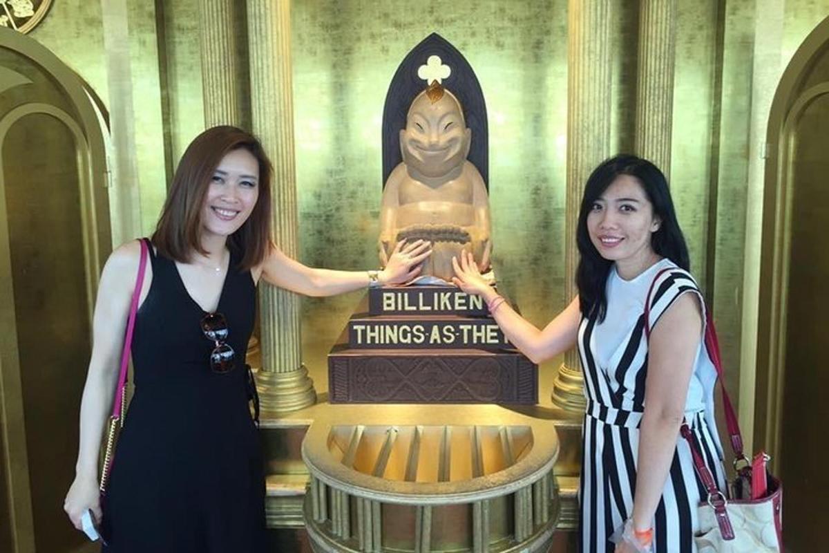 Dos mujeres están paradas frente a una estatua.