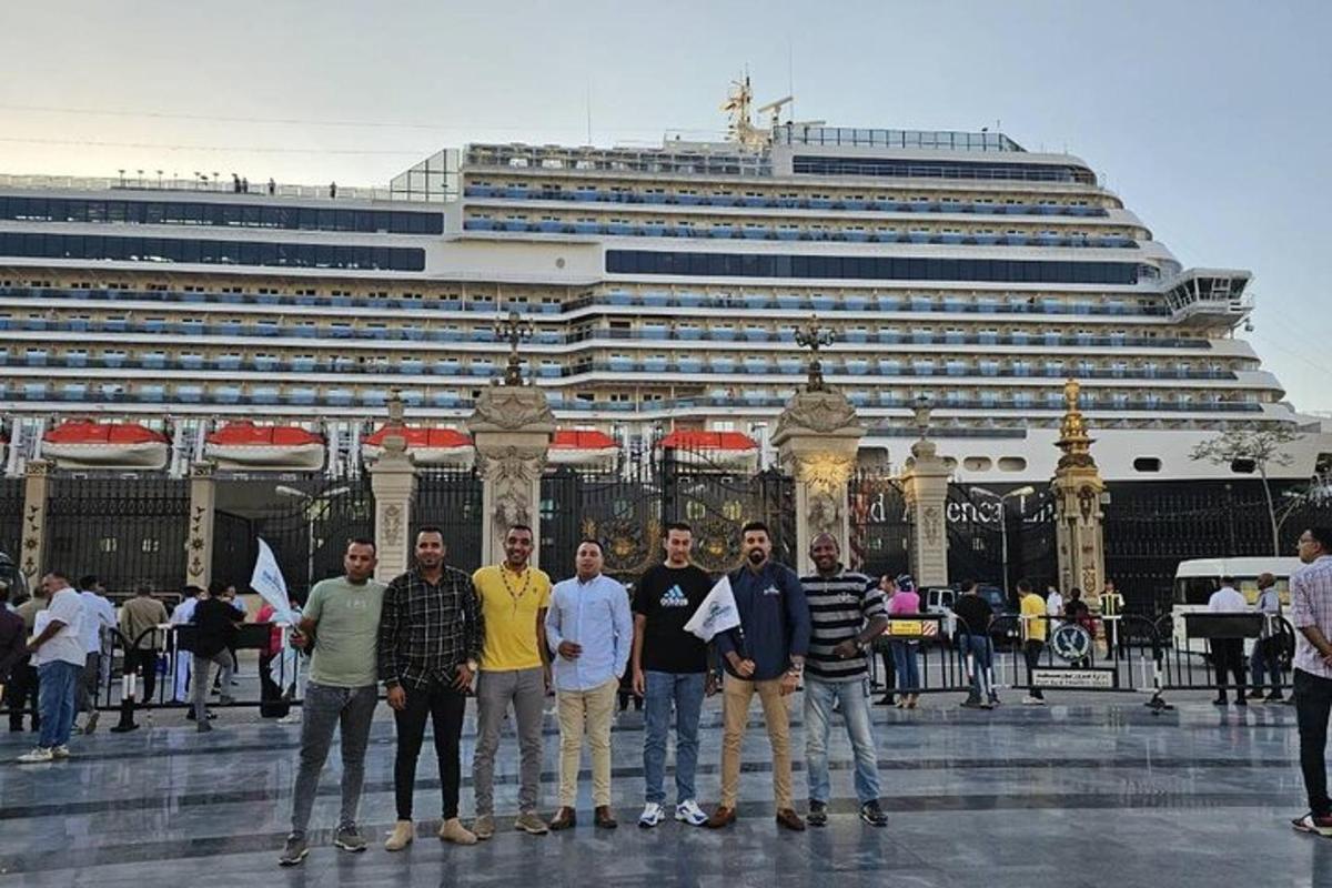un gruppo di persone in piedi davanti a una nave da crociera