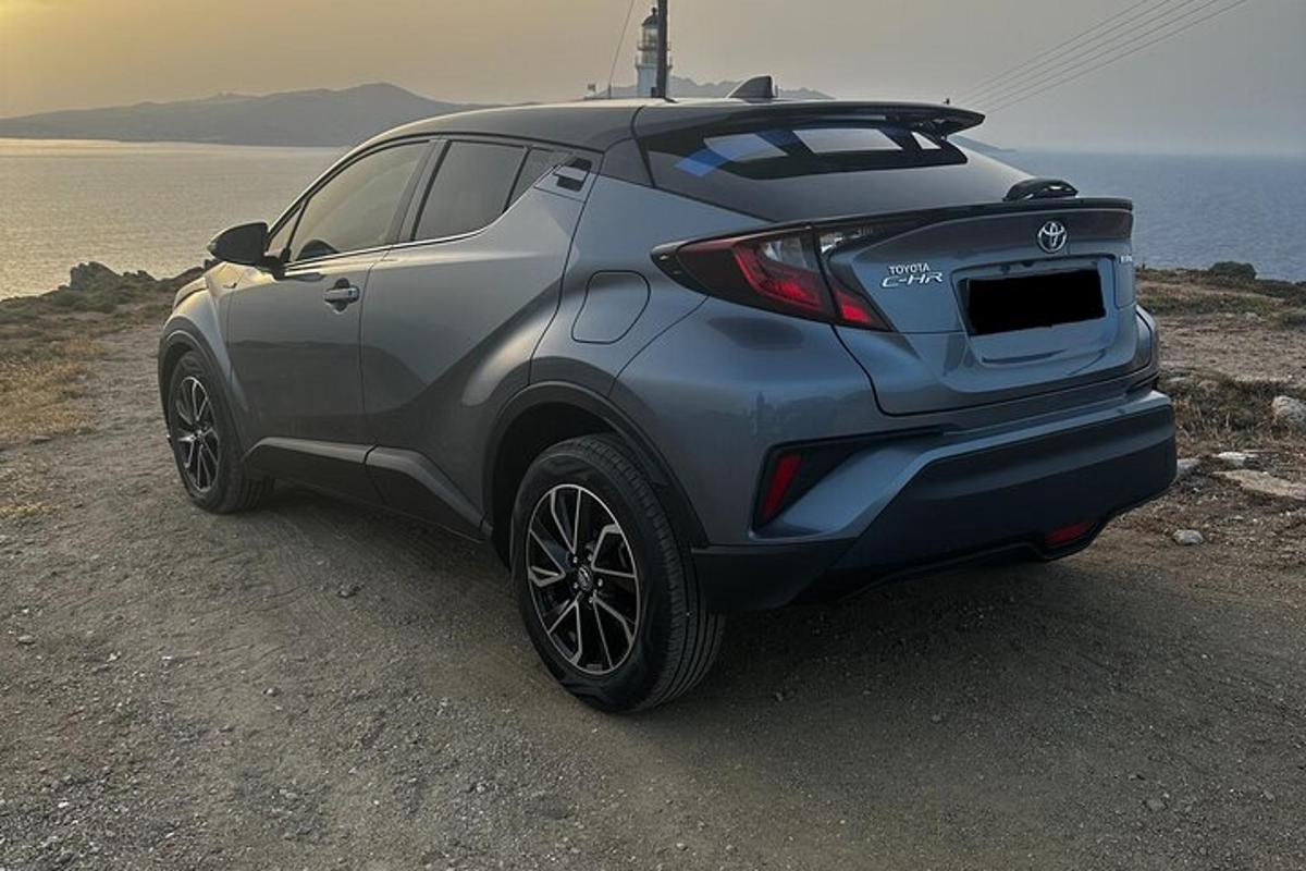 en sølvfarvet SUV parkeret på en grusvej nær havet