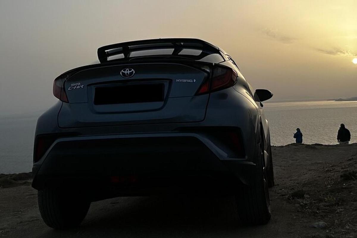 um carro estacionado em uma praia perto do oceano