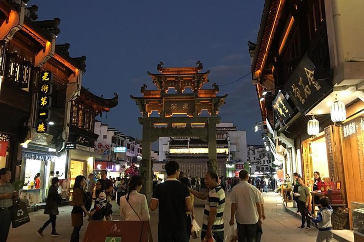 a crowd of people walking down a street at night