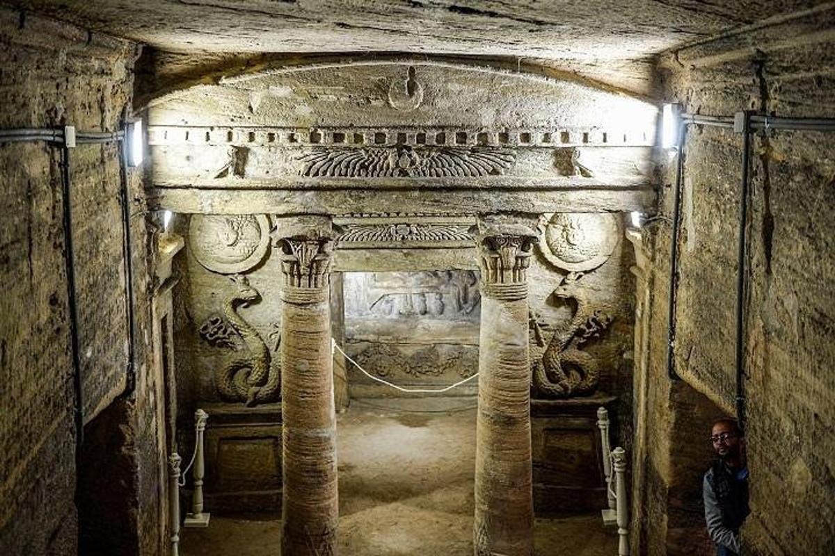 un uomo in piedi all'interno di una grotta con colonne