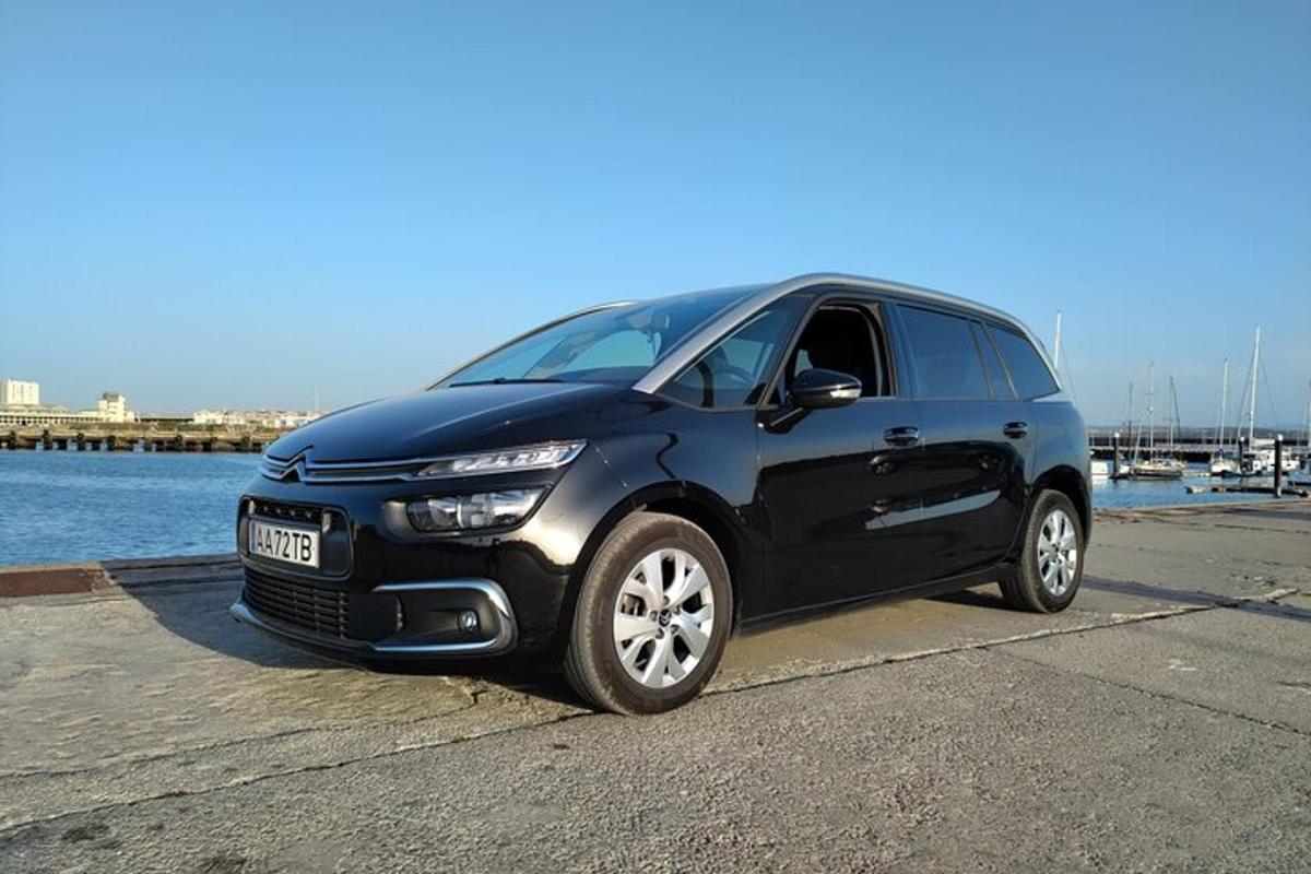 um carro preto estacionado próximo a um corpo d'água