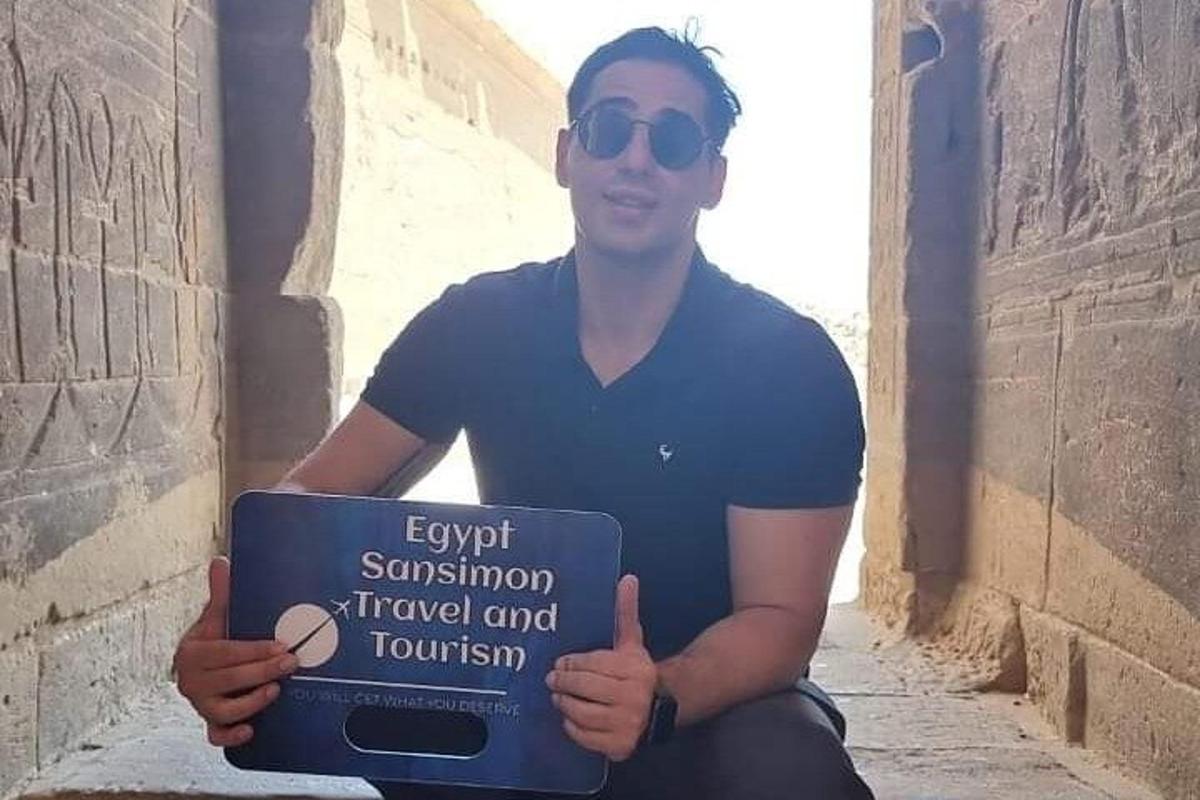Mees hoiab käes silti kirjaga "väljumispeatus" reisimine ja turism