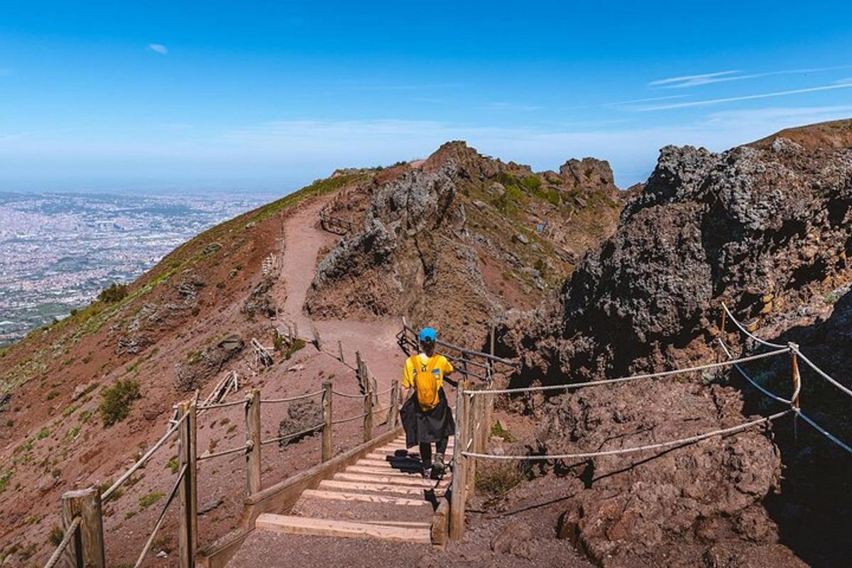 seorang lelaki berjaket kuning berdiri di atas gunung