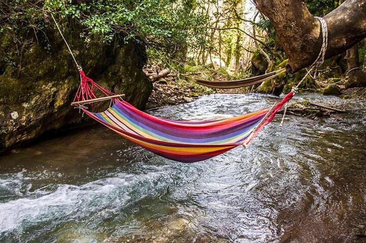 a hammock hanging over a stream in a river
